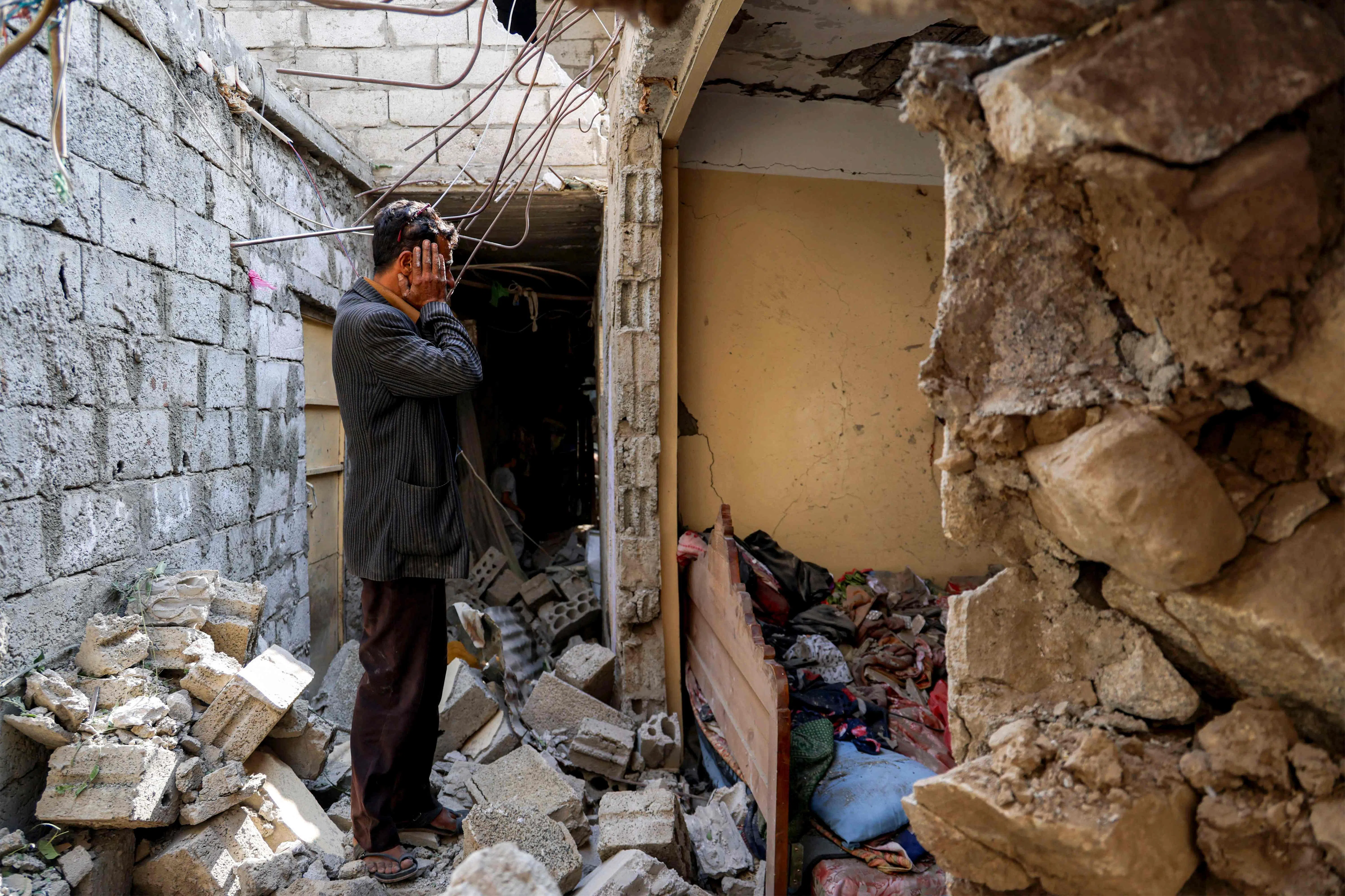 TOPSHOT - A man reacts as he stands before a destroyed building in the aftermath of a reported missile attack on a residential neighbourhood in Taiz in western Yemen on October 20, 2026. (Photo by Ahmad AL-BASHA / AFP)