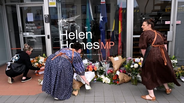 People lay flowers outside the office of Australian politician Helen Haines.