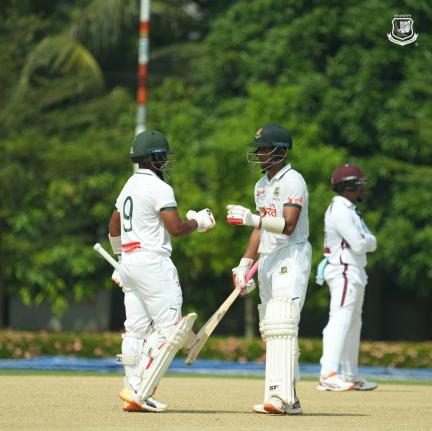 A Bangladesh XI pair congratulate each other mid-pitch during their two-day warm-up match against the West Indies yesterday.