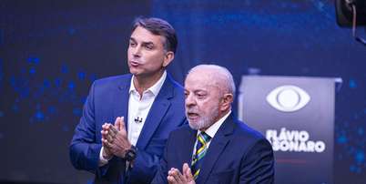 Lula e Flávio Bolsonaro durante debate da Band neste domingo, 18 Foto: BRUNO MOTTA/ENQUADRAR / Estadão