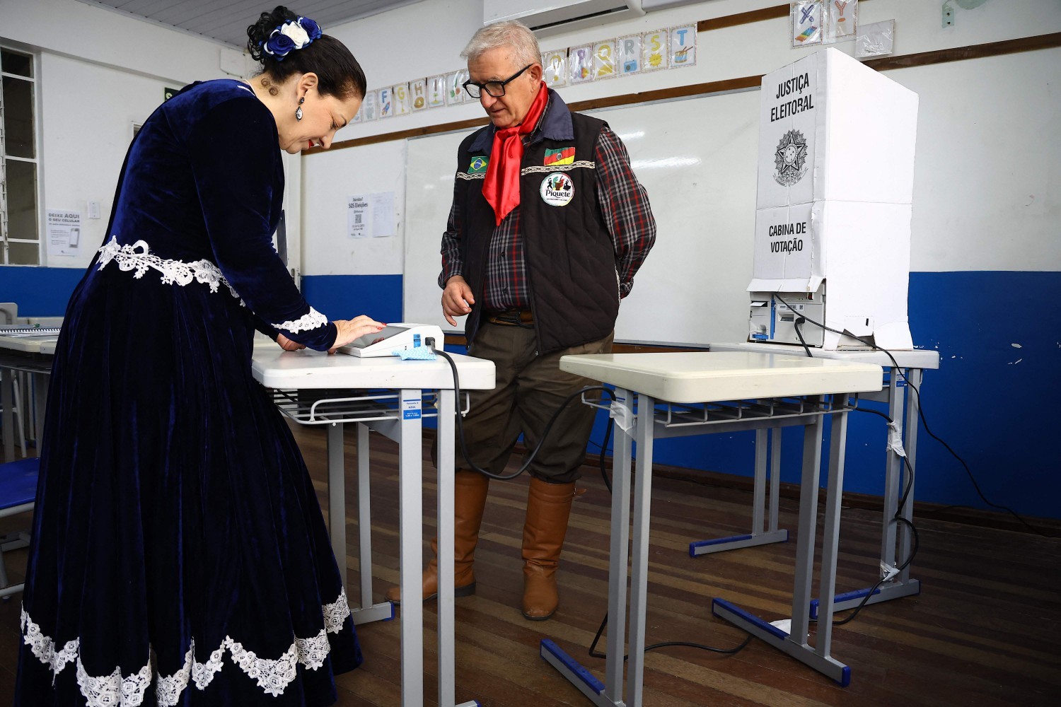 Eleitor vestido com trajes tradicionais gaúchos vota em uma seção eleitoral em Viamão, no estado do Rio Grande do Sul — Foto: SILVIO AVILA / AFP